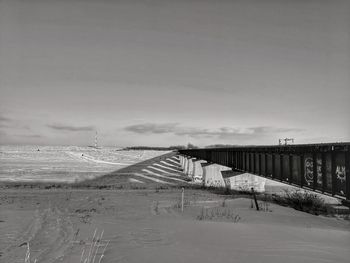 Scenic view of snow covered bridge against sky