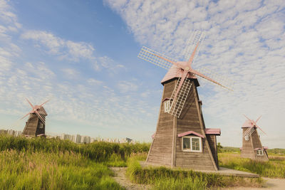 Traditional windmill on field against sky