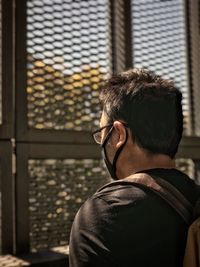 Side view of young man gazing out.