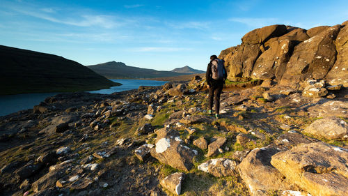 Rear view of hiker walking on land