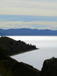 Scenic view of sea and mountains against sky