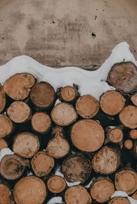 Stack of wood with snow layered on top.