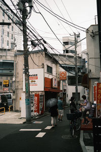 People on road against buildings in city