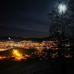 Illuminated city against sky at night