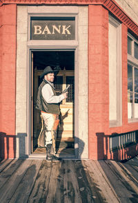 Full length of man standing at entrance of building