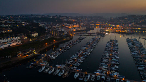 High angle view of illuminated city buildings against sky at dusk