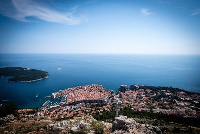 High angle view of townscape by sea against sky