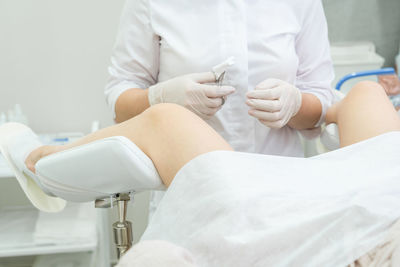 Midsection of gynecologist examining patient