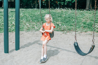 Full length of girl sitting on swing