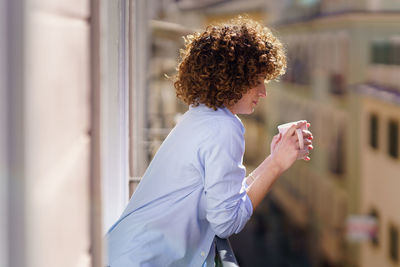 Side view of young woman using mobile phone