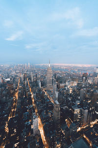 High angle view of city buildings against cloudy sky