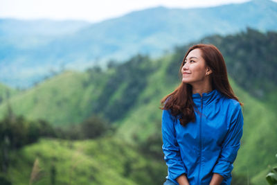 Portrait image of female traveler with a beautiful green mountains view