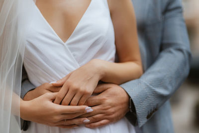 Midsection of couple holding hands