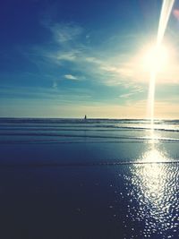 Sun shining through clouds over sea