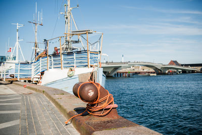 Sailboat with bridge behind it against sky