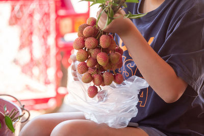 Midsection of woman holding fruits