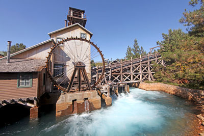 Traditional water wheel against clear blue sky