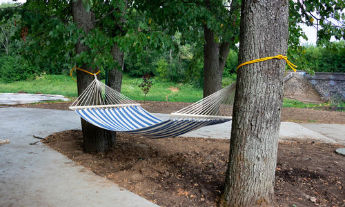Hammock made of natural fabric, suspended from ropes in the garden on trees