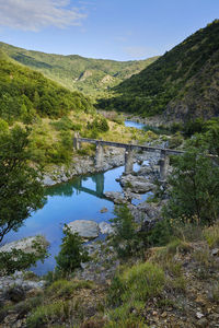 Arch bridge over lake against sky