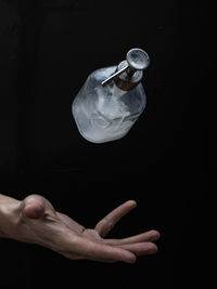 Digital composite image of man hand against black background