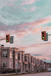 Low angle view of road signal against buildings in city