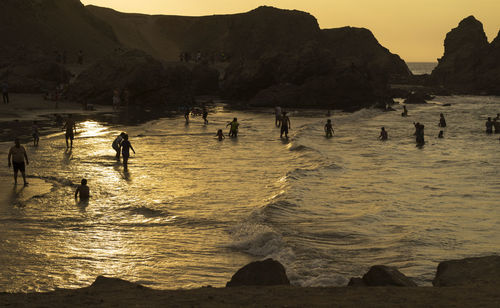 Personas disfrutando de un día relajante de verano en la playa durante el atardecer