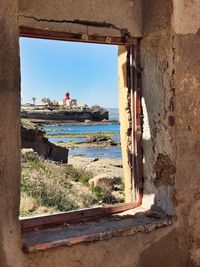 Coastline seen through abandoned house window