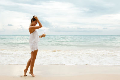 Full length of woman standing at beach