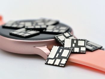Close-up of clock on table against white background