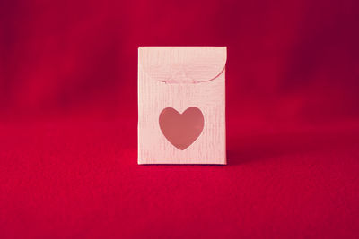 Close-up of heart shape on red table