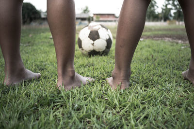 Low section of boys playing soccer on field