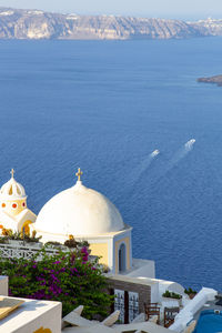 Buildings by sea against mountain