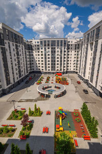 High angle view of buildings by street against sky