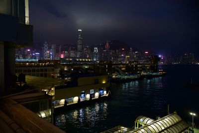 Illuminated skyscrapers facing victoria harbour against sky at night in spring