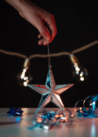 Close-up of hand holding christmas decoration on table