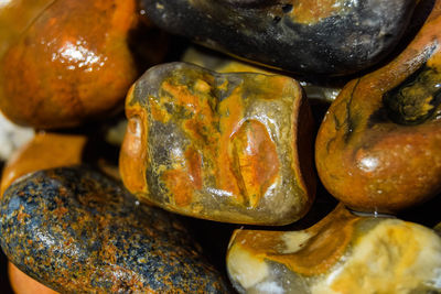 Close-up full frame shot of colourful wet pebbles on beach