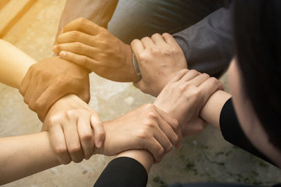 Cropped image of business people holding hands