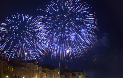 Low angle view of firework display at night