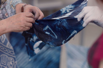 Midsection of women holding textile at clothing store