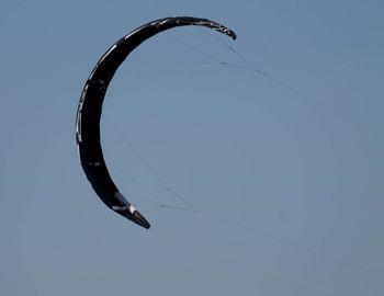 Low angle view of kite flying against clear blue sky