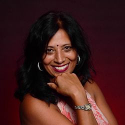Portrait of smiling woman with hand on chin against colored background