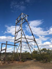 Low angle view of metallic structure on field against sky