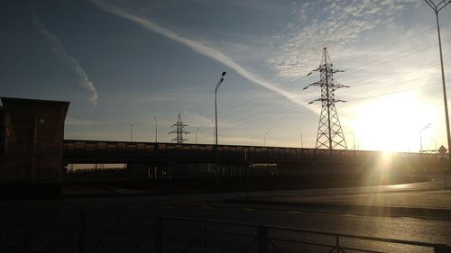 Silhouette electricity pylon against sky during sunset