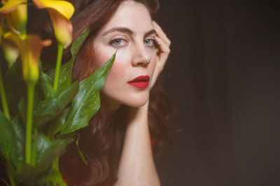 Close-up portrait of beautiful woman by plants