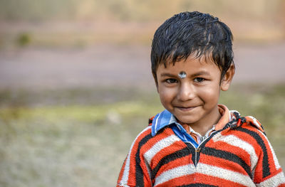 Portrait of smiling boy standing outdoors