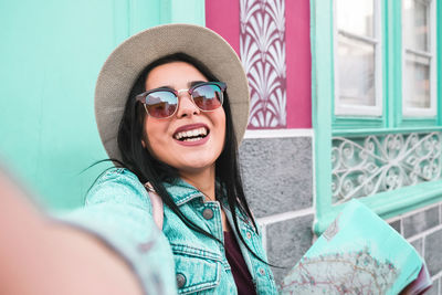 Portrait of smiling young woman wearing sunglasses