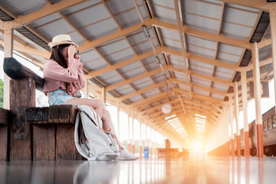 Woman photographing at railroad station platform