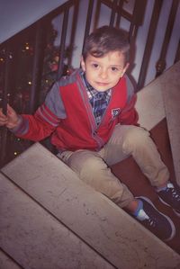 Portrait of smiling boy sitting outdoors