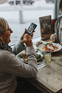 Woman photographing food on table