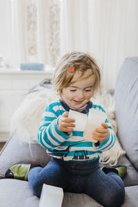 Girl playing with containers on sofa at home